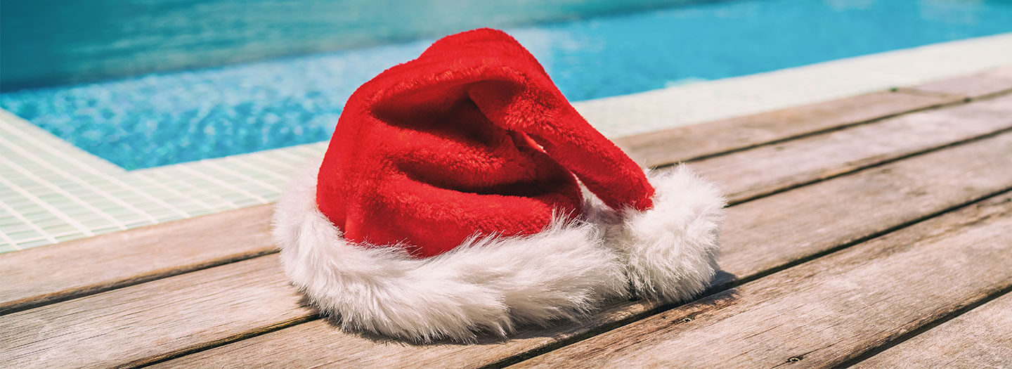 Evoking Christmas in July, a Santa Claus hat sits on a pool deck