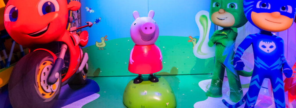 A Peppa Pig model stands between models of Ricky Zoom and PJ Masks.