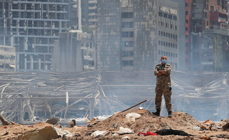 A soldier stands at the devastated site of the explosion in the port of Beirut, Lebanon, Thursday, Aug. 6, 2020.