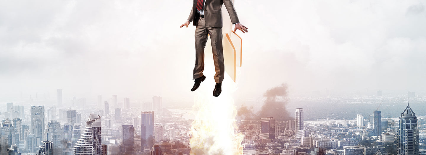 A man with a jetpack flies into the air above skyscrapers