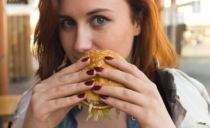 A woman dines on a hamburger
