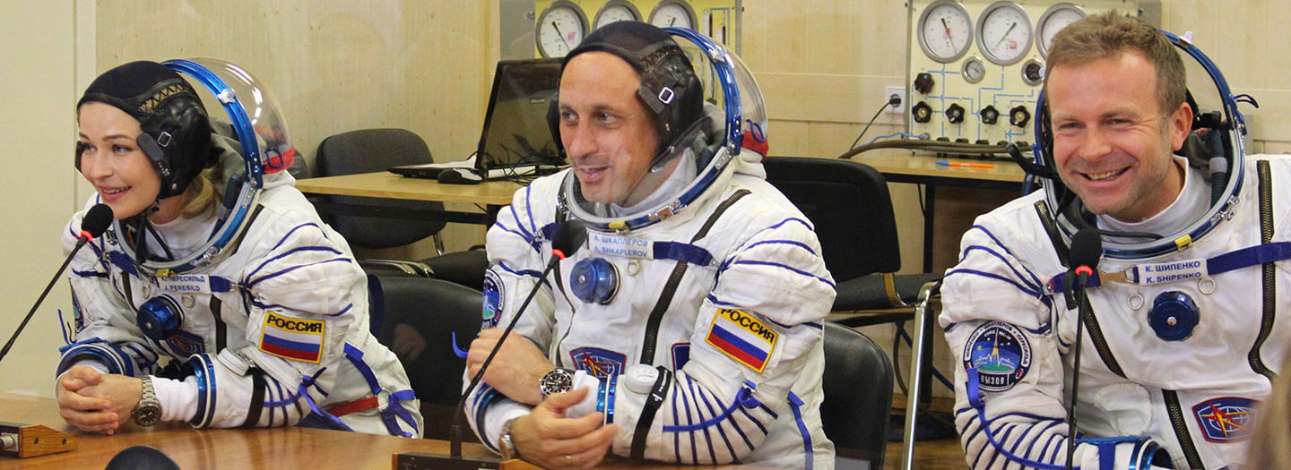 In this handout photo released by Roscosmos, actress Yulia Peresild, left, film director Klim Shipenko, right, and cosmonaut Anton Shkaplerov speak with their relatives through a safety glass prior the launch at the Baikonur Cosmodrome, Kazakhstan, Tuesday, Oct. 5, 2021.