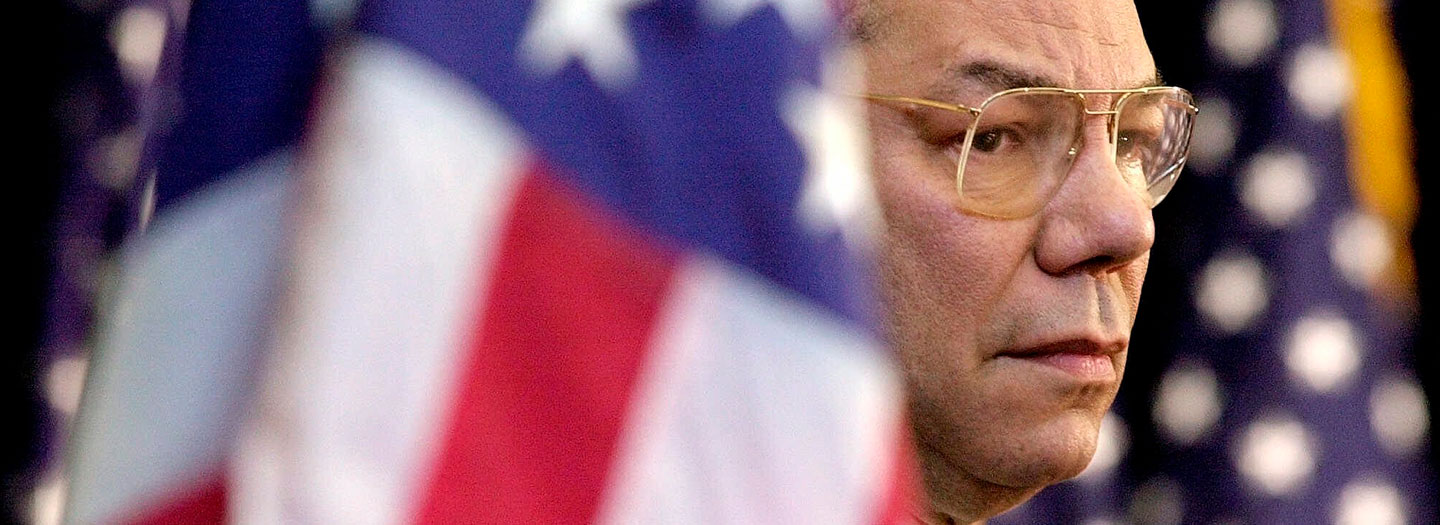 In this Feb. 15, 2001 file photo, Secretary of State Colin Powell looks on as President Bush addresses State Department employees at the State Department in Washington. (AP Photo/Kenneth Lambert)