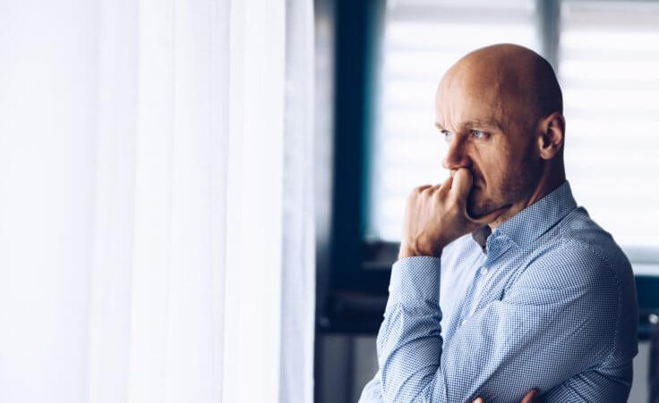 A man rests his hand on his chin in a pensive state. © Daniel Jędzura/stock.adobe.com