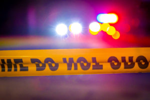 Stock photo: Crime scene tape in front of police lights at night. © Ajax9/stock.adobe.com
