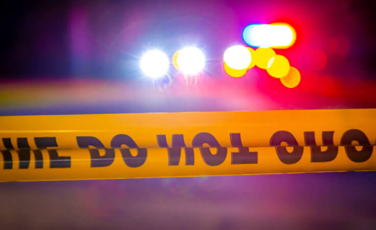 Stock photo: Crime scene tape in front of police lights at night. © Ajax9/stock.adobe.com