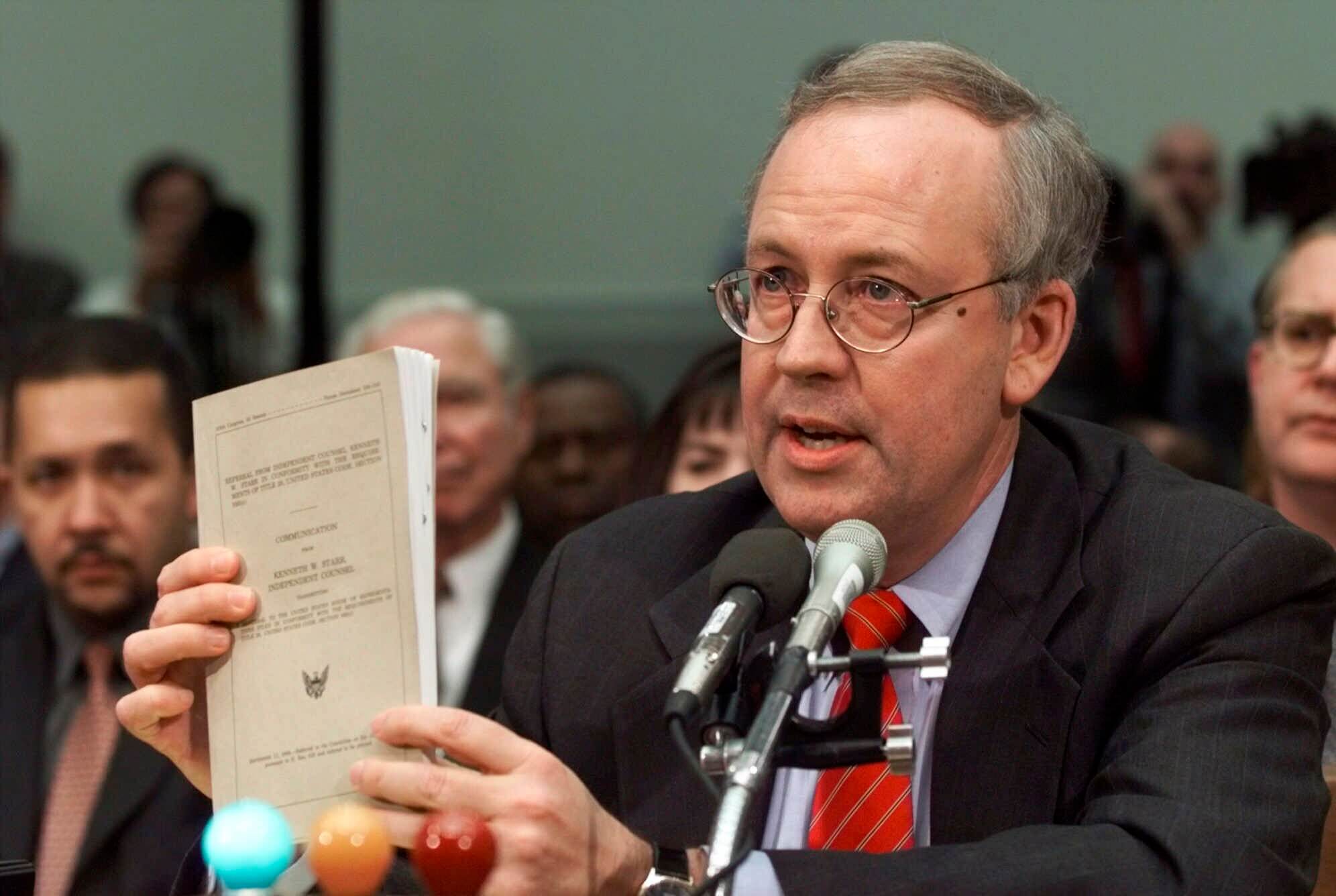 FILE - Independent Counsel Kenneth Starr holds a copy of his report while testifying on Capitol Hill Thursday Nov. 19, 1998, before the House Judiciary Committee's impeachment hearing. Starr, whose criminal investigation of Bill Clinton led to the president’s impeachment, died Sept. 13, 2022. He was 76. (AP Photo/Doug Mills, File)