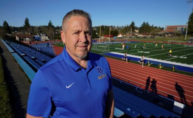 Joe Kennedy, a former assistant football coach at Bremerton High School in Bremerton, Wash., poses for a photo March 9, 2022, at the school's football field.