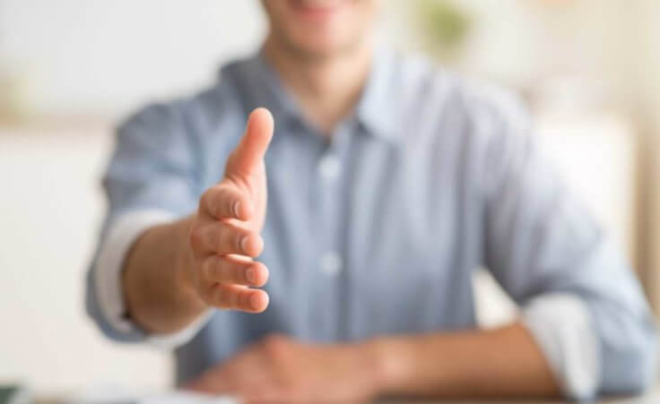 A man stretches his hand out toward the camera, waiting for a handshake. © Prostock-studio/stock.adobe.com