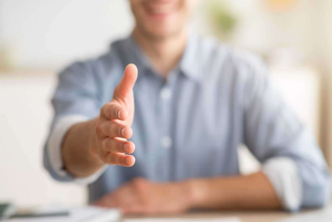 A man stretches his hand out toward the camera, waiting for a handshake. © Prostock-studio/stock.adobe.com