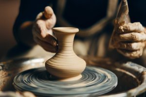 Close up on hands shaping clay vase