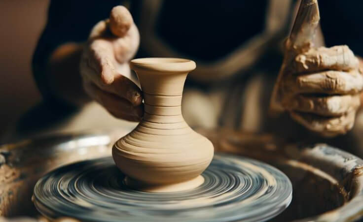 Close up on hands shaping clay vase