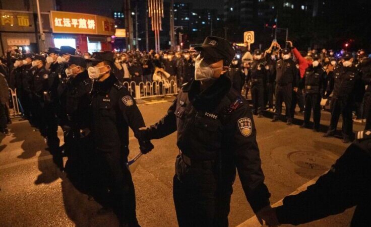 Chinese policemen form a line to stop protesters marching in Beijing, Sunday, Nov. 27, 2022. Protesters angered by strict anti-virus measures called for China's powerful leader to resign, an unprecedented rebuke as authorities in at least eight cities struggled to suppress demonstrations Sunday that represent a rare direct challenge to the ruling Communist Party. (AP Photo/Ng Han Guan)