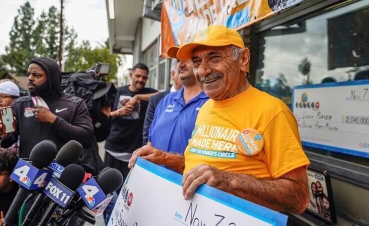 Business owner Joe Chahayed holds a $1 million check outside Joe's Service Center in Altadena, CA.