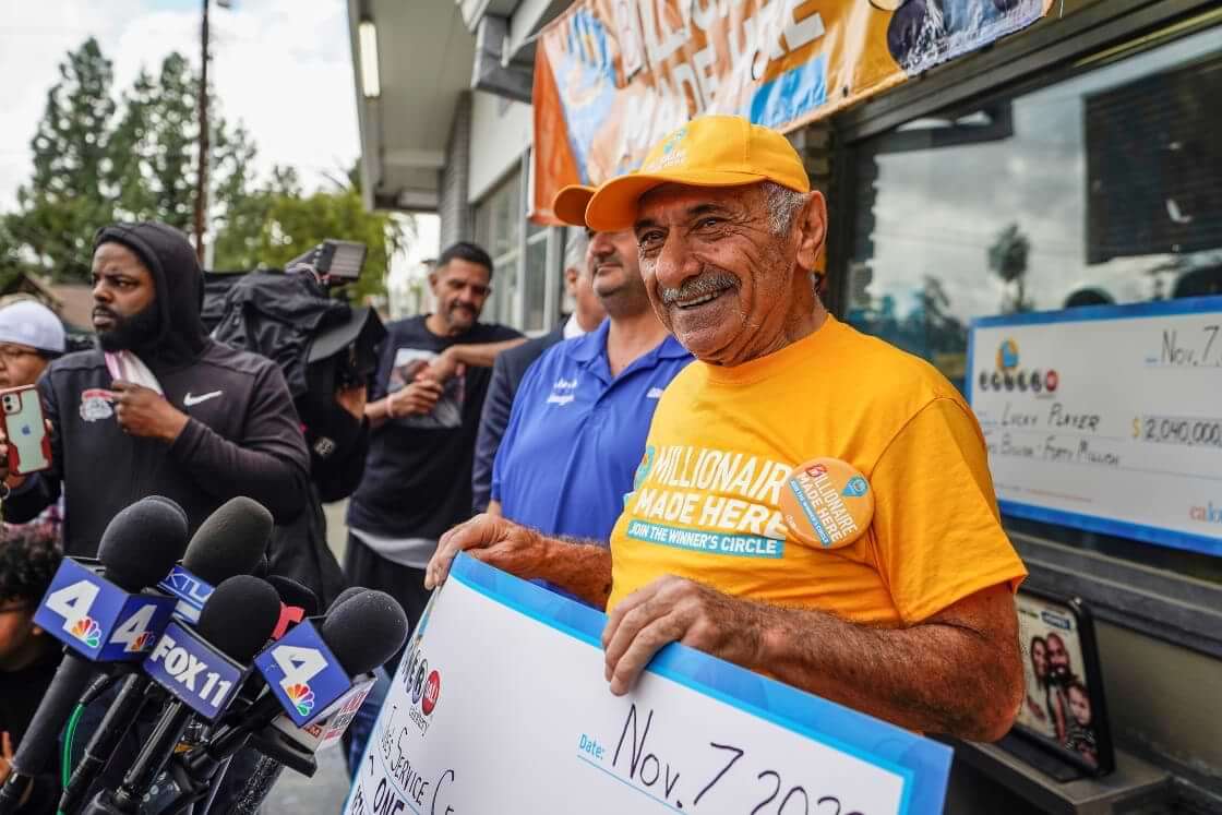 Business owner Joe Chahayed holds a $1 million check outside Joe's Service Center in Altadena, CA.