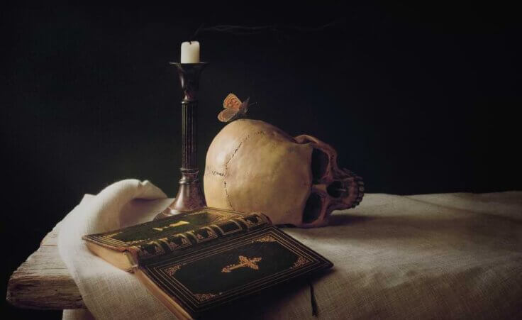 Skull, Bible, candle, and butterfly on a table