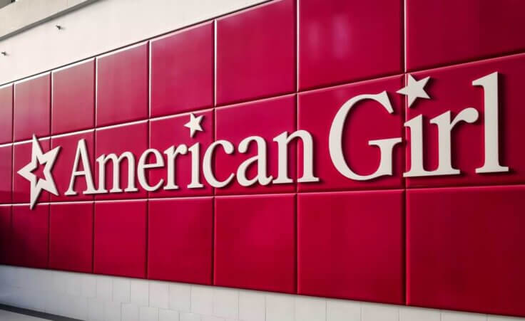 The American Girl logo in white on a tiled red background.