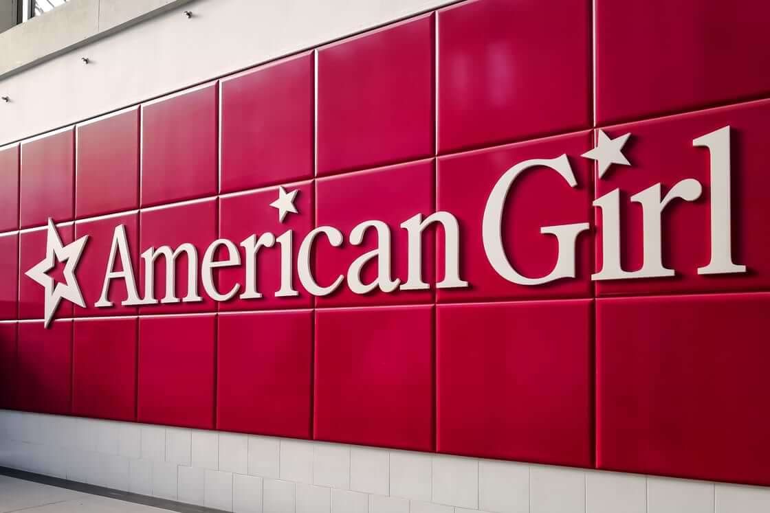 The American Girl logo in white on a tiled red background.