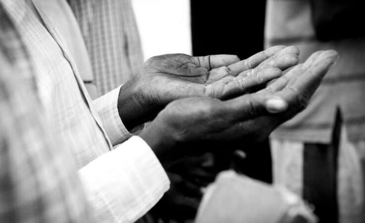 Hands of man praying in South Sudan. By Wollwerth Imagery/stock.adobe.com