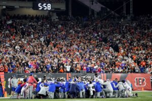 Buffalo Bills players and staff pray for Buffalo Bills' Damar Hamlin during the first half of an NFL football game against the Cincinnati Bengals, Monday, Jan. 2, 2023, in Cincinnati. The game has been postponed after Buffalo Bills' Damar Hamlin collapsed, NFL Commissioner Roger Goodell announced. (AP Photo/Joshua A. Bickel)