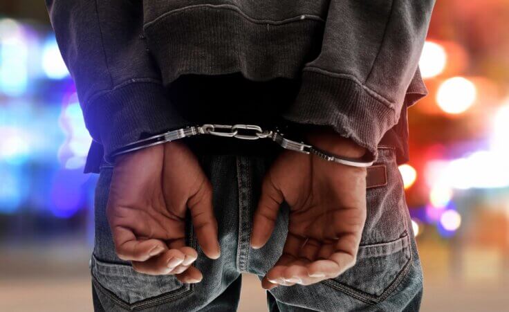 Closeup of a man's handcuffed hands behind his back. © By fotokitas/stock.adobe.com