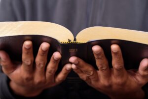 Open hands hold an open Bible. © By Sevenstock Studio/stock.adobe.com