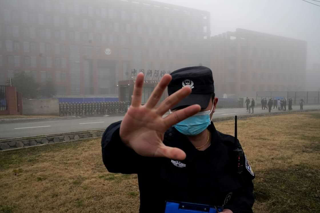 FILE - A security person moves journalists away from the Wuhan Institute of Virology after a World Health Organization team arrived for a field visit in Wuhan in China's Hubei province on Feb. 3, 2021. (AP Photo/Ng Han Guan, File). The US Energy Department has concluded that the COVID origin was most likely a lab leak.