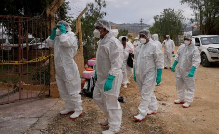 Health workers in protective gear enter a chicken farm during a health alert due to a bird flu outbreak in Sacaba, Bolivia, Tuesday, Jan. 31, 2023. Bolivian health authorities reported on Jan. 30 that thousands of birds were culled after an outbreak of bird flu on farms, forcing the declaration of a 120-day health emergency. (AP Photo/Juan Karita)