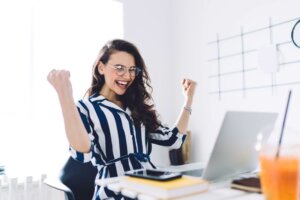 Stock photo: A young woman celebrates, arms and fists in the air, in front of an open laptop. © By BullRun/stock.adobe.com. Canadian lottery winner Juliette Lamour is the youngest winner of Canada's lottery, winning $48 million on her 18th birthday.