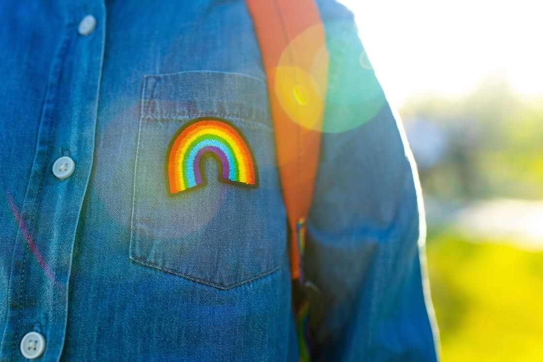Child with backpack and rainbow button. Schools in Austin set to celebrate pride week