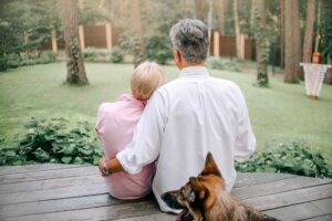 Pastor taking rest spending time with his wife. The middle-aged pastor sits next to his wife on their back porch, overlooking a yard.