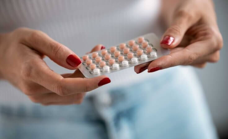 A woman holds birth control pills in her hands. © By nenetus/stock.adobe.com