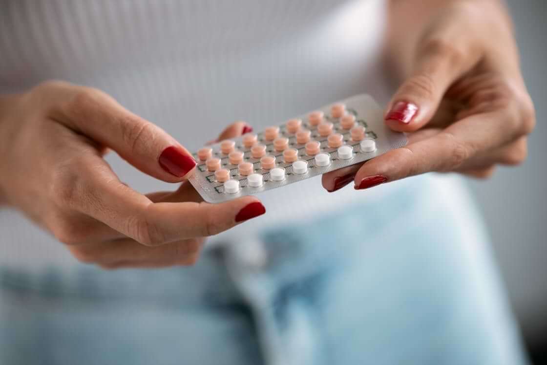 A woman holds birth control pills in her hands. © By nenetus/stock.adobe.com