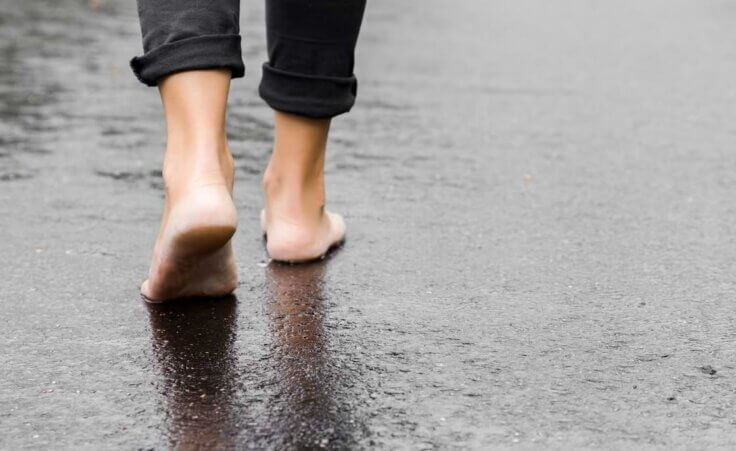 A man in black pants walks barefoot on a beach. © By fotoduets/stock.adobe.com