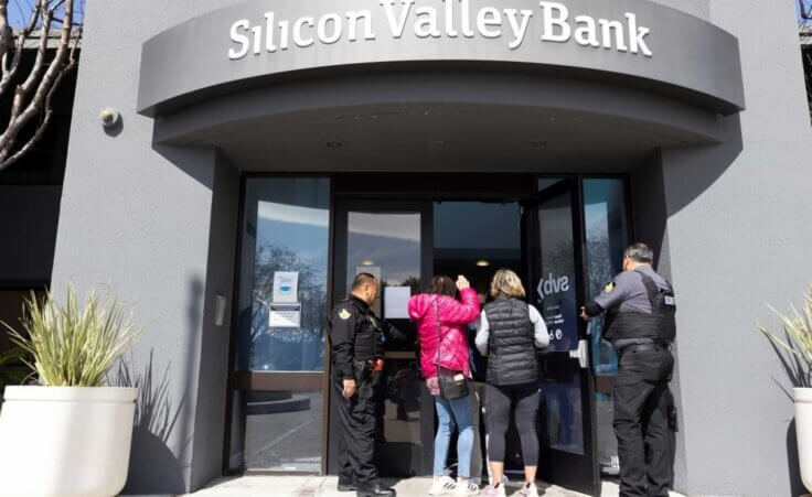 Security guards let individuals enter the Silicon Valley Bank's headquarters in Santa Clara, Calif., on Monday, March 13, 2023. The federal government intervened Sunday to secure funds for depositors to withdraw from Silicon Valley Bank after the bank's collapse. Dozens of individuals waited in line outside the bank to withdraw funds. (AP Photo/ Benjamin Fanjoy)