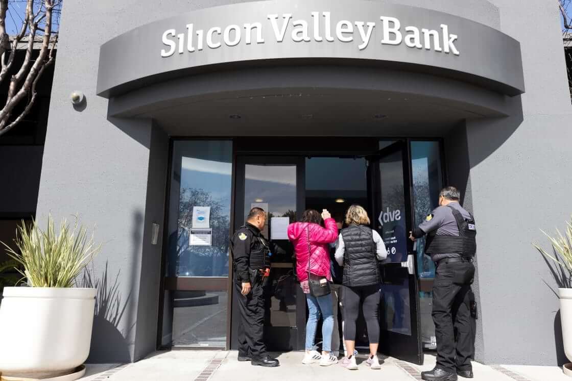 Security guards let individuals enter the Silicon Valley Bank's headquarters in Santa Clara, Calif., on Monday, March 13, 2023. The federal government intervened Sunday to secure funds for depositors to withdraw from Silicon Valley Bank after the bank's collapse. Dozens of individuals waited in line outside the bank to withdraw funds. (AP Photo/ Benjamin Fanjoy)