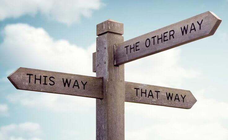 A wooden sign points in three directions: this way, that way, and the other way—indicative of a pastor's search for their calling.