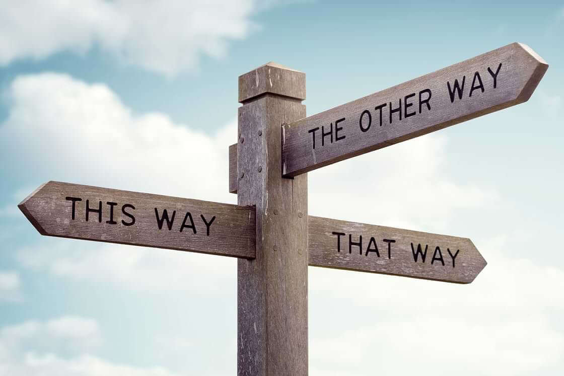 A wooden sign points in three directions: this way, that way, and the other way—indicative of a pastor's search for their calling.