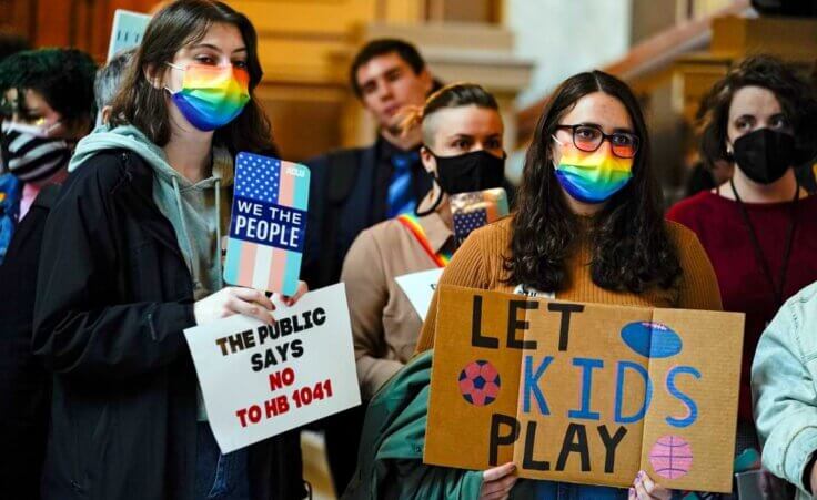 FILE - People gather to protest against HB1041, a bill to ban transgender women and girls from participating in school sports that match their gender identity, during a rally at the Statehouse in Indianapolis, Wednesday, Feb. 9, 2022. (AP Photo/Michael Conroy File)