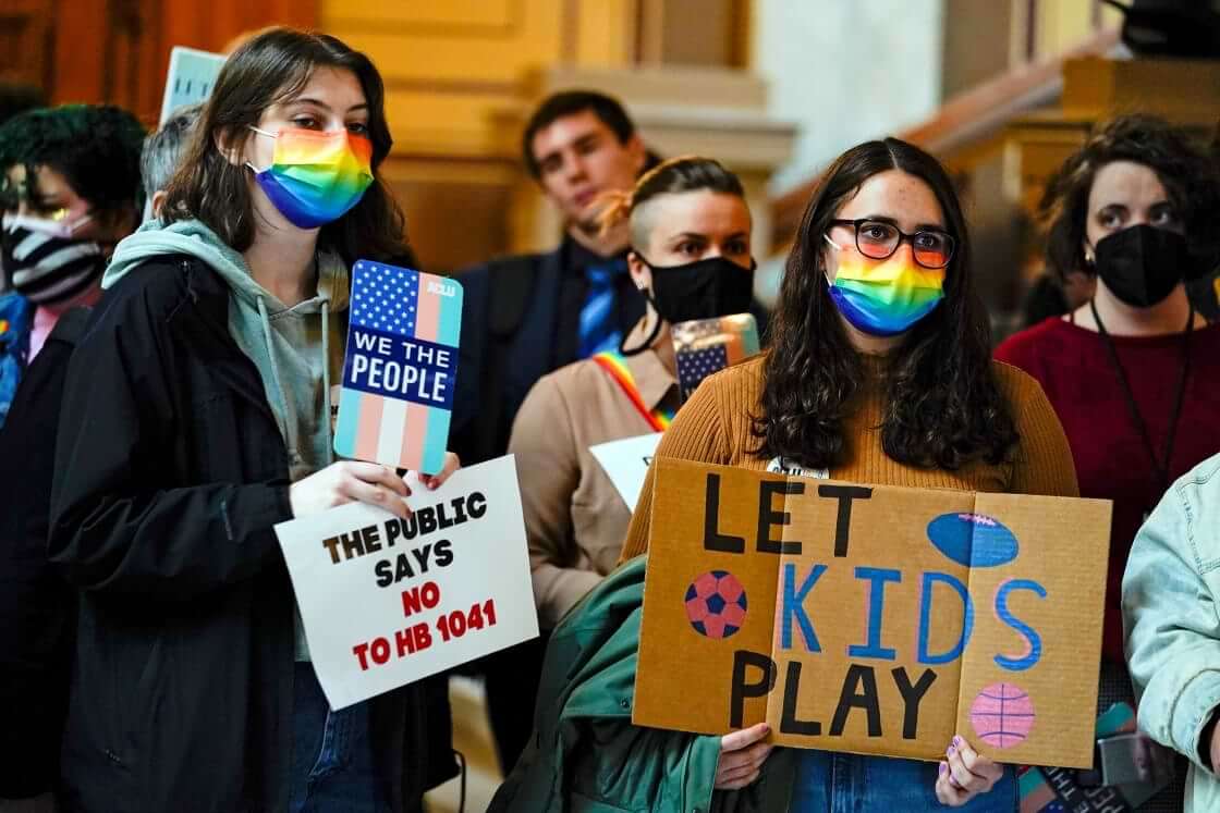 FILE - People gather to protest against HB1041, a bill to ban transgender women and girls from participating in school sports that match their gender identity, during a rally at the Statehouse in Indianapolis, Wednesday, Feb. 9, 2022. (AP Photo/Michael Conroy File)