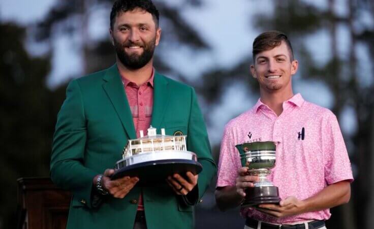 Jon Rahm, of Spain, holds up the Masters trophy as Sam Bennett holds the low amateur trophy after the Masters golf tournament at Augusta National Golf Club on Sunday, April 9, 2023, in Augusta, Ga. (AP Photo/David J. Phillip)