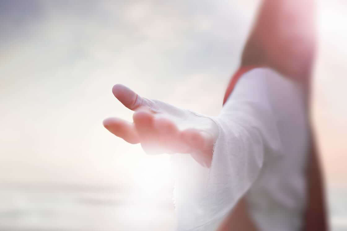 Representación de un artista de Jesús con una túnica blanca extendiendo su mano © By artpluskr/stock.adobe.com