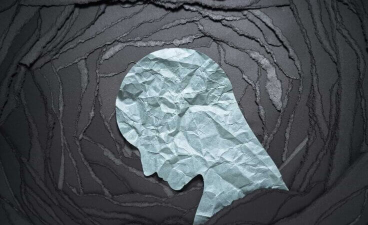 Silhouette of depressed and anxiety person head. Negative emotion image. Person head shaped paper on black torn paper background.