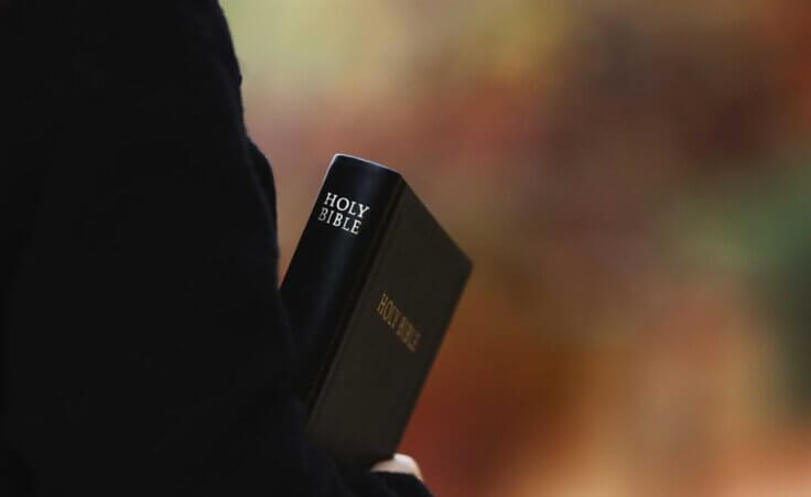 Man holding a bible. Charles Stanley was an influential Baptist pastor. He died in April of 2023