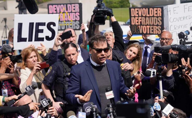 U.S. Rep. George Santos leaves the federal courthouse surrounded by reporters and protestors