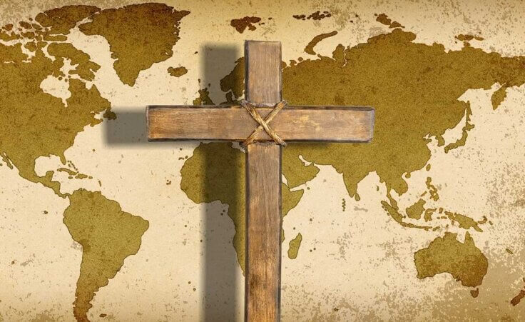 A cross lays atop a world map, a reminder of International Day for the Unreached © By BillionPhotos.com/stock.adobe.com