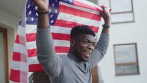 A black man raises an American flag behind and above his head. © By CameraCraft/stock.adobe.com. According to the Smithsonian Institution, “Juneteenth marks our country’s second independence day.”