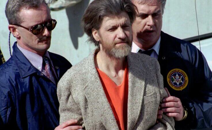 Theodore "Ted" Kaczynski is flanked by federal agents as he is led to a car from the federal courthouse in Helena, Mont., April 4, 1996.