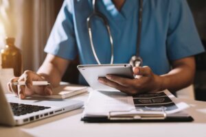 Medical student working on laptop in scrubs