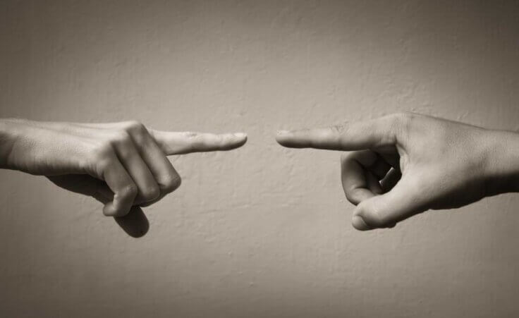 Two people pointing at each other in argument